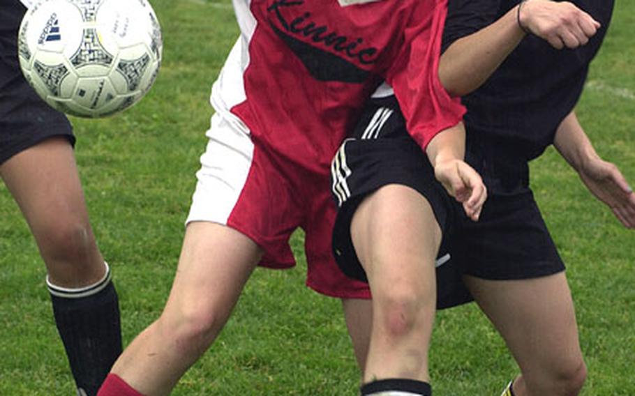 Nikki Fulton of the Nile C. Kinnick Red Devils and Yvonne Castillanos of the Zama American Trojans battle for the ball during Saturday&#39;s final of the Department of Defense Dependents Schools-Japan girls soccer tournament at Reid Memorial Stadium, Atsugi Naval Air Facility, Japan.