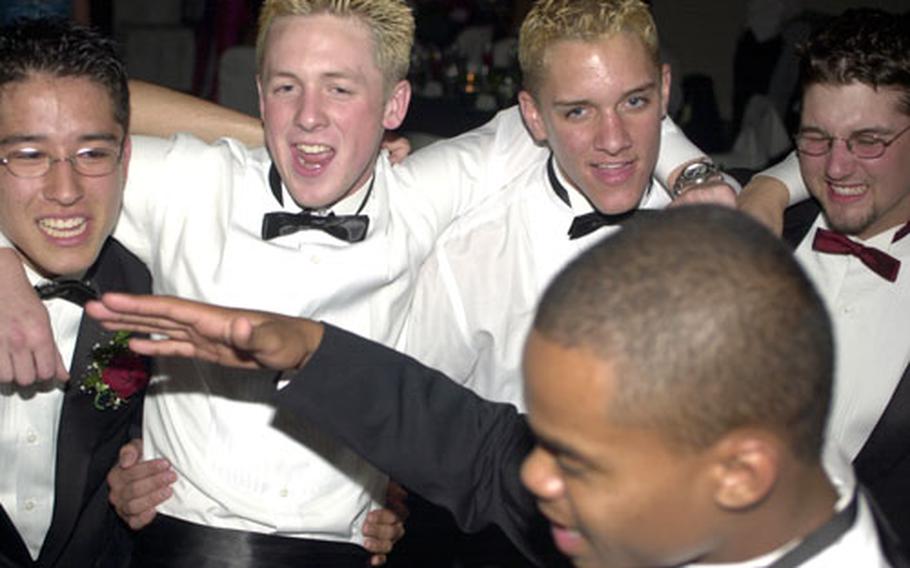 Yokota High School baseball pitcher Shawn Novak, soccer striker Jay Irwin, soccer defenceman Ross Miles and baseball player Jason Correll surround track sprinter Danny Corprew while singing Queen&#39;s "We Are The Champions" during their prom Saturday at the New Sanno Armed Forces Centre, Tokyo.