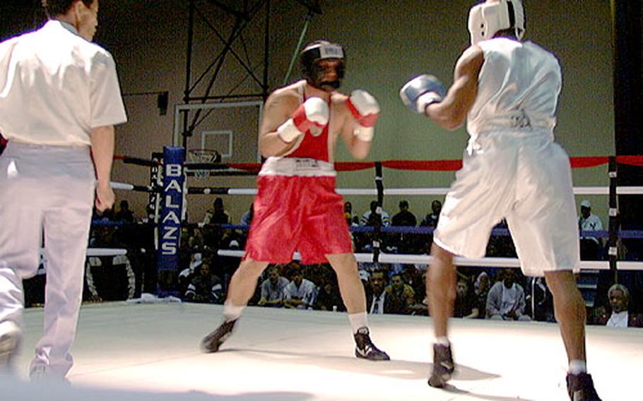 Army Staff Sgt. Johnny Dockery measures his opponent, Robert Flores, during the debut of the Army boxing program for lower South Korea in March at Camp Walker. The program has expanded to Camp Carroll, and Dockery is the post boxing team&#39;s new coach.