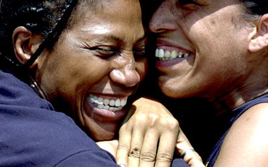 Christine Kemp and Vicki Pryor of Okinawa&#39;s TPS Diamonds share a congratulatory hug after the Diamonds beat Red Fox, a Korean semi-pro team, in a two-game final.