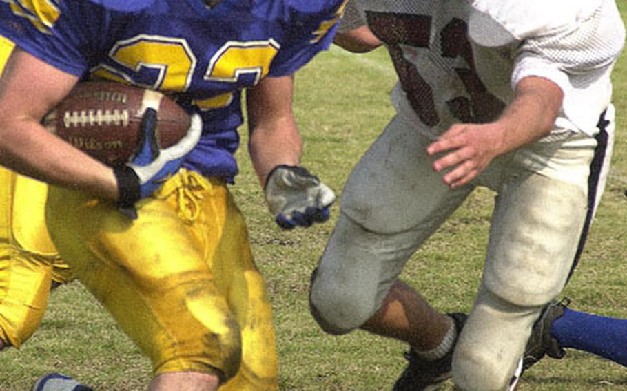 Yokota Panthers tailback Mike Chamberlain (23) tries to outrun the pursuit of Matthew C. Perry Samurai defender Darien Garland (53) during an Oct. 5, 2002, Japan Football League game at Bonk Field, Yokota Air Base, Japan. Chamberlain accounted for 185 all-purpose yards and scored four touchdowns on 17 touches as Yokota routed Perry 57-6. Chamberlain was named Stars and Stripes Pacific high school male Athlete of the Year for the second straight year.