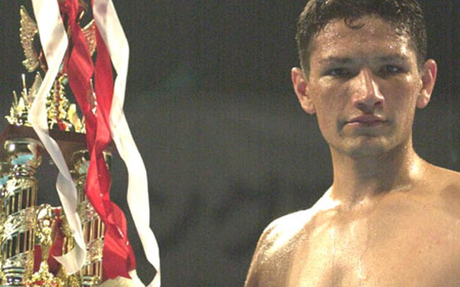 David Archuleta displays the championship trophy after Sunday&#39;s Universal Kickboxing Federation junior-welterweight championship bout at Differ Ariake, Tokyo. Archuleta beat fellow American Steve Satterwhite by knockout at 2:58 of the first round. The reigning Okinawa welterweight champion, Archuleta, 20, a senior airman assigned to the 733rd Air Mobility Squadron at Kadena Air Base, Okinawa, improved to 17-2-1 with 11 knockouts. Satterwhite fell to 21-2 with 11 knockouts.