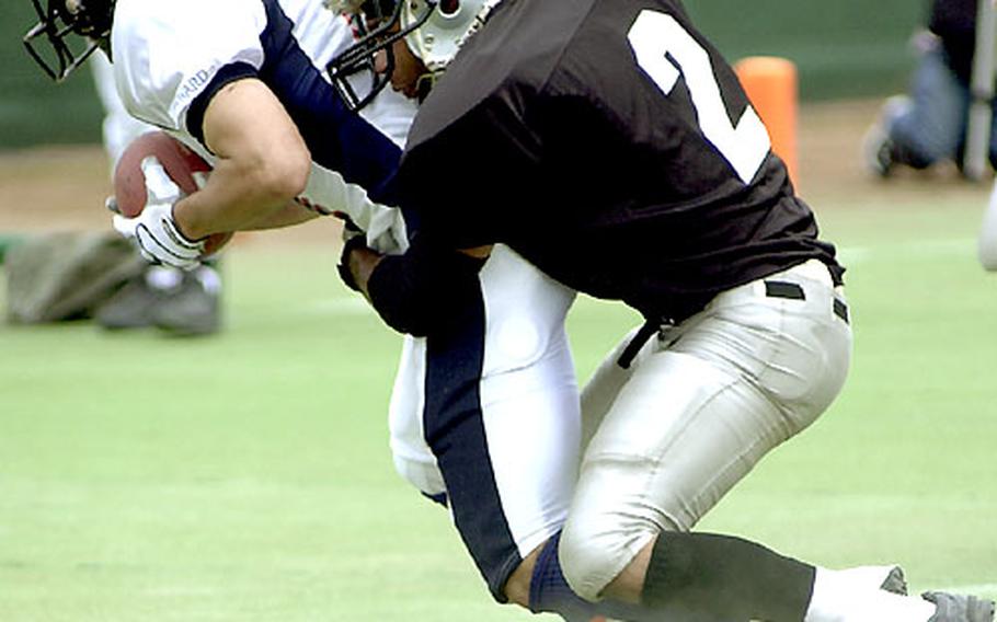 Yokota Raiders defensive back R.C. Curry (2) tries in vain to keep receiver Hidemoto Jin of the Onward Skylarks out of the end zone.
