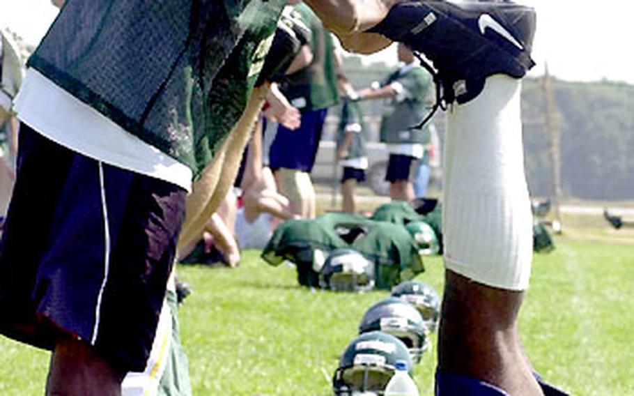 Ryan Butler of AFNORTH, standing, and David Kennedy of Patch go through a warm-up session at the 2003 European Football Camp in Bitburg, Germany.