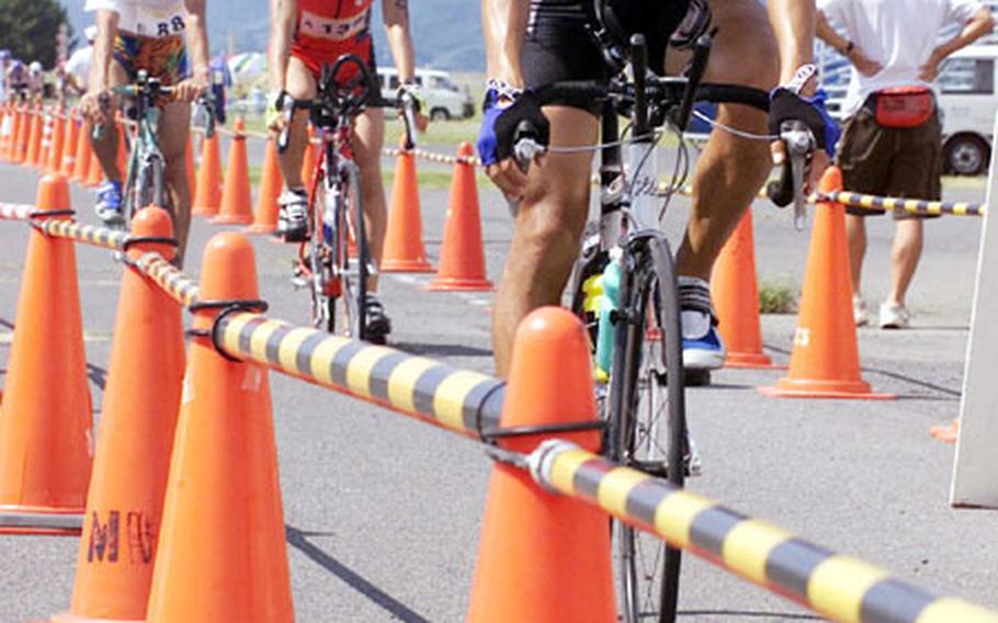 Junjiro Ishikura, in front, Sprint Triathlon participant, completes another lap around Iwakuni Marine Corps Air Station during the bicycling portion of the event last year as Yutaka Ishibashi attempts to close the distance between the two.