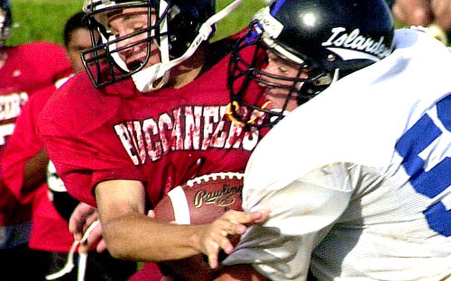 Kadena Islanders defensive lineman Grady Pennell, right, tackles Kadena Buccaneers quarterback Tyler Schmidt for a one-yard loss during Monday's game. Pennell had a sack and a fumble recovery to help the Islanders blank the Buccaneers 6-0.