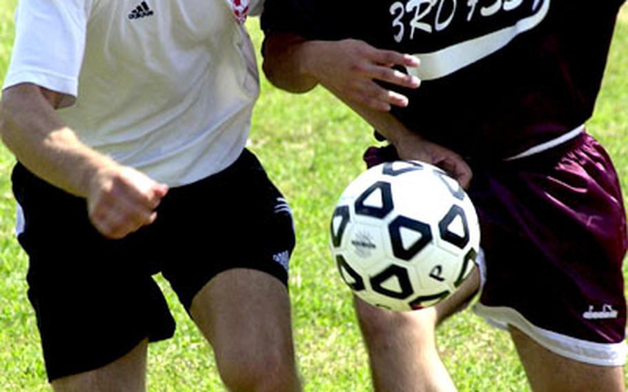 Michael Gibson, left, of Marine Corps Base Hawaii battles for the ball with Jonathan Alzate of Okinawa&#39;s 3rd Force Service Support Group.