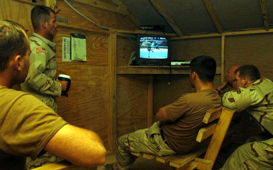 Members of the Illinois National Guard&#39;s 333rd MP Company watch the final few innings of the final game of the Chicago Cubs-Florida Marlins National League Championships Series. Unit members had to wake up early Thursday morning to watch the game, in which the Cubs lost 9-6 and were eliminated from the playoffs.