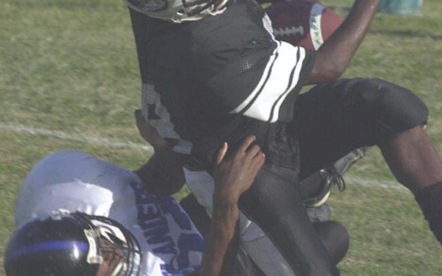 Kubasaki Samurai running back Thaddeus Reap is wrestled down by Kadena Islanders defender David McCowan during Friday&#39;s game. The Islanders blanked the Samurai 68-0, the worst defeat in the Samurai&#39;s history.