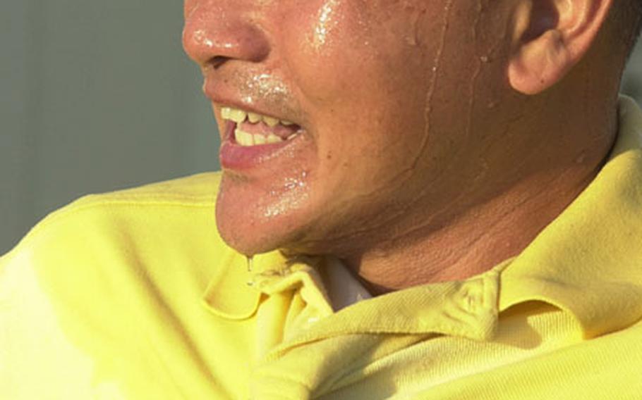 Coach Hoa Nguyen of Okinawa&#39;s Kadena Panthers smiles after getting the water bucket treatment for finishing second in the Far East High School Tennis Tournament — Kadena&#39;s best finish since winning the event 14 years ago.