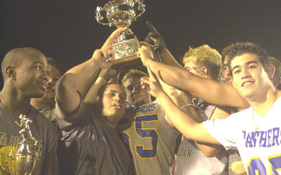 Yokota Panthers seniors Roy Roach, Isaac Felarca, Jason Barajas, Jason Correll, Karl Gerstner, Jeremiah Pearcey and James Ritton hoist the Rising Sun Bowl trophy Saturday at McDonald Stadium, Kadena Air Base, Okinawa. The Panthers got two touchdowns each from Roach and Pearcey to win their fourth straight All-Japan championship 31-3 over the Kadena Buccaneers.