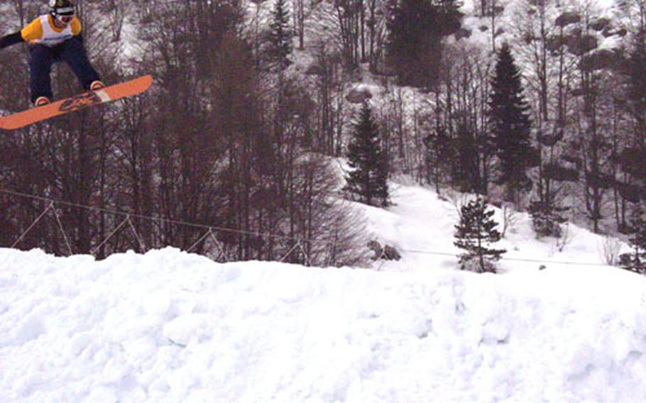 Andrew Gardner gets some air Saturday on the last ramp during his heat victory in the Boardercross event at the U.S. Forces Ski and Snowboard Championships in Piancavallo, Italy. Gardner, a senior airman at nearby Aviano Air Base, went on to triumph in the men&#39;s open category.