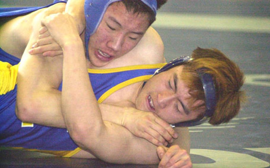 Alex Kim, top left, of Seoul American grapples with Pil Yun of Yokota during Wednesday&#39;s 122-pound pool bout in the Far East High School Wrestling Tournament at Yokota Air Base, Japan. Kim decisioned Yun 15-7.