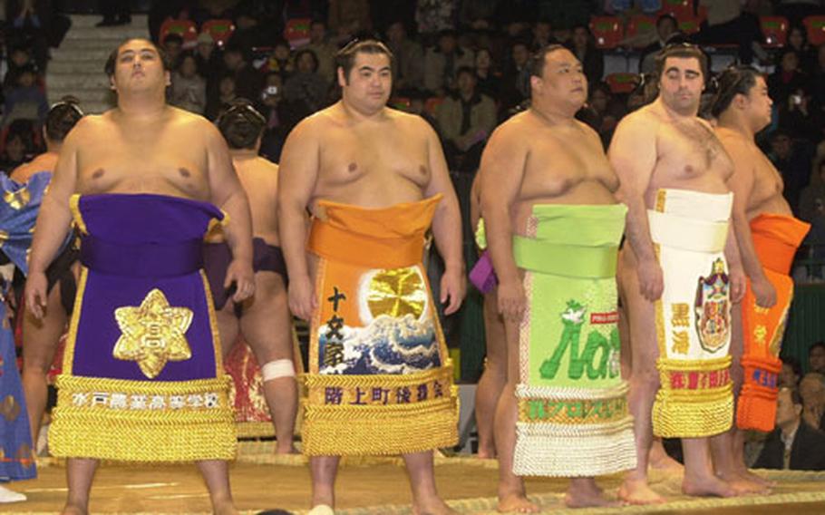 A line of sumo wrestlers preens for the crowd during the opening ceremony of the first sumo tournament to be held in South Korea since the end of Japanese colonial rule.