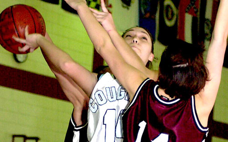 Suzi Devin of Osan American tries to shoot over Dayna Garland (14) of Matthew C. Perry of Japan during Tuesday's round-robin play.