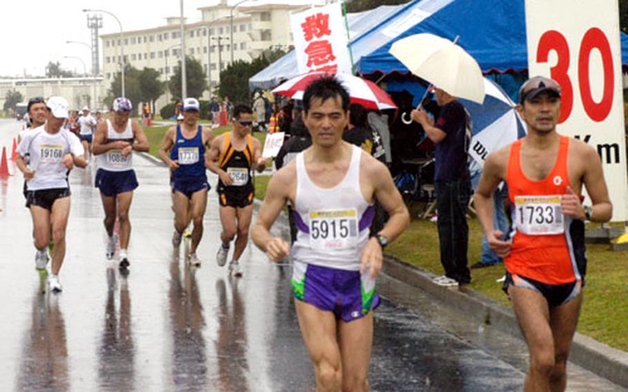 Runners in the 12th annual Okinawa Marathon stride through Kadena Air Base&#39;s gate #2 and past the 30-Km checkpoint. The race course was set thru 12 different cities, towns, and villages of central Okinawa.