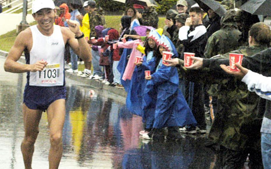 A runner in the Okinawa Marathon smiles as he passes volunteers and well-wishers near Kadena Air Base’s Exchange.