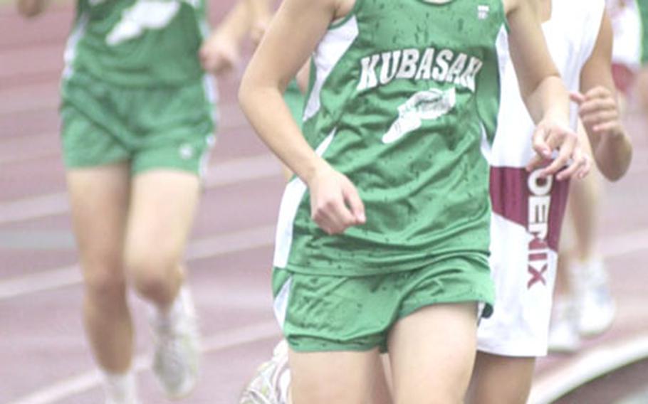 Kubasaki sophomore distance specialist Crystal Sandness takes the lead from freshman Yuna Sakuma of Tokyo's Seisen International School during the girls 3,200-meter in the 2nd Dr. Alva W. "Mike" Petty Memorial Track and Field Meet at Mike Petty Stadium, Kubasaki High School, Camp Foster, Okinawa.