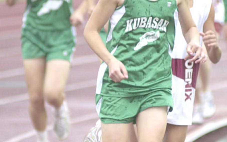 Kubasaki sophomore distance specialist Crystal Sandness takes the lead from freshman Yuna Sakuma of Tokyo&#39;s Seisen International School during the girls 3,200-meter in the 2nd Dr. Alva W. "Mike" Petty Memorial Track and Field Meet at Mike Petty Stadium, Kubasaki High School, Camp Foster, Okinawa.