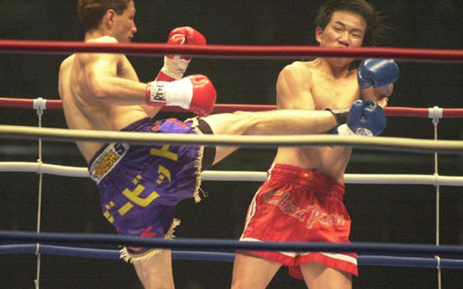 Senior Airman David Archuleta, from the 733rd Air Mobility Squadron at Kadena Air Base, scores a kick to his opponent, Kang En from China, at a K-1 fighting match in Tokyo Wednesday.