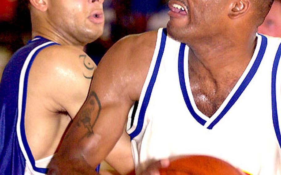 Marine Corps Base Hawaii’s Darnell Butler goes up for a shot against Justin Brown of Okinawa’s 1st Marine Aircraft Wing on Monday in the 2004 Marine Forces Pacific Regional Basketball Tournament.