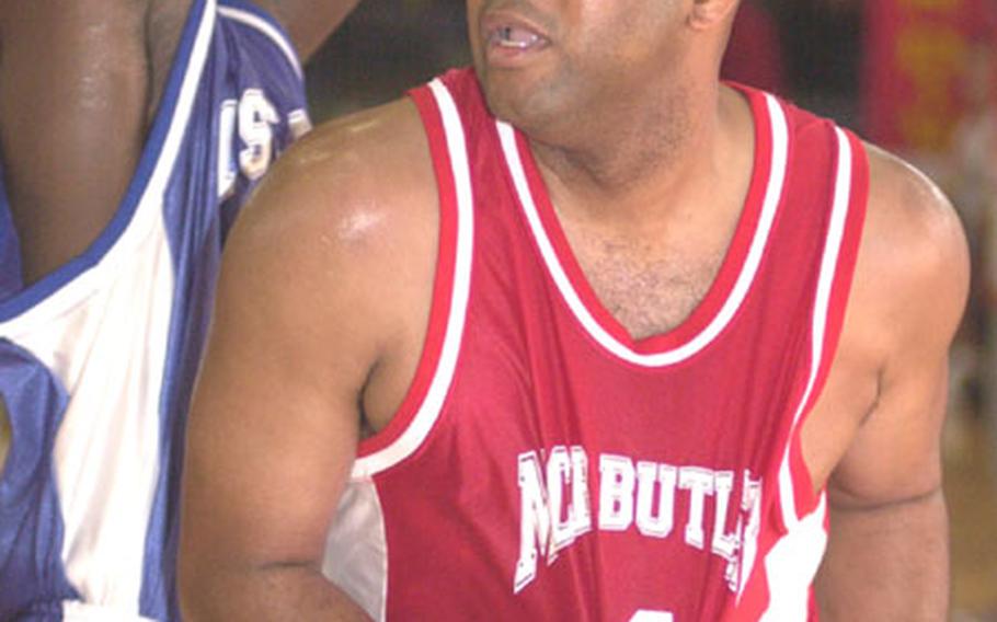 Yonnes Sanders of Marine Corps Base Camp Butler looks for shooting room against Clarence Crafton of 1st Marine Aircraft Wing during Saturday&#39;s championship game in the 2004 Marine Forces Pacific Regional Basketball Tournament at Kinser Sports and Fitness Center, Camp Kinser, Okinawa.