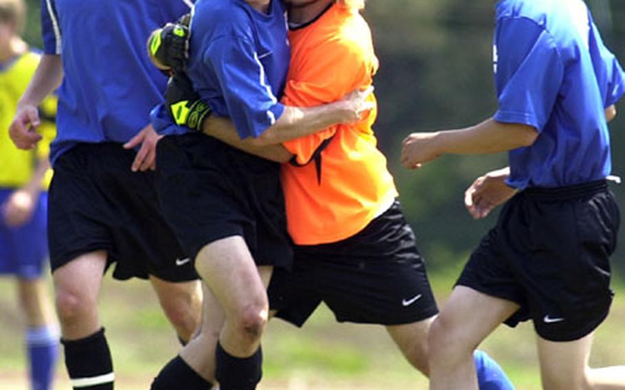 London Central goalie Mark Pierce, third from left, congratulates Seth Hansen on his first-half goal against Bamberg on the opening day action of the 2004 DODDS-Europe soccer championships in Ramstein, Germany, on Thursday.