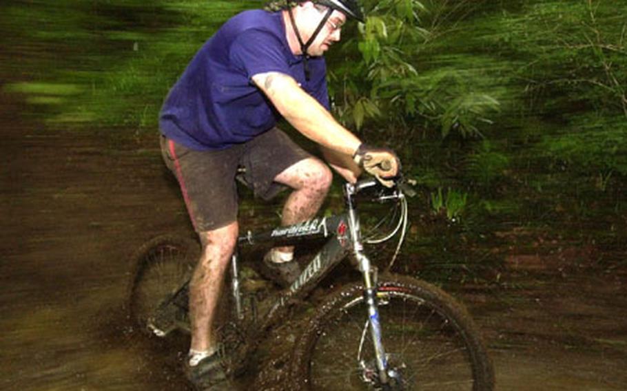 Staff Sgt. Matt Butts take a mud puddle in the 14th Tour de Tama mountain bike race at Tama Hills Saturday.