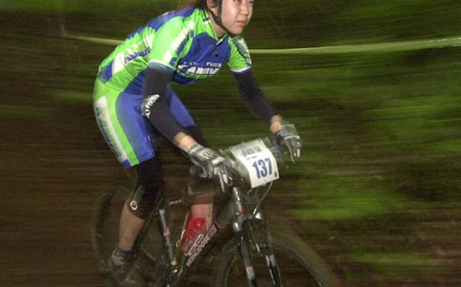 Sachiko Takeda rides her bike through the muddy course of the Tour de Tama at Tama Hills Saturday.