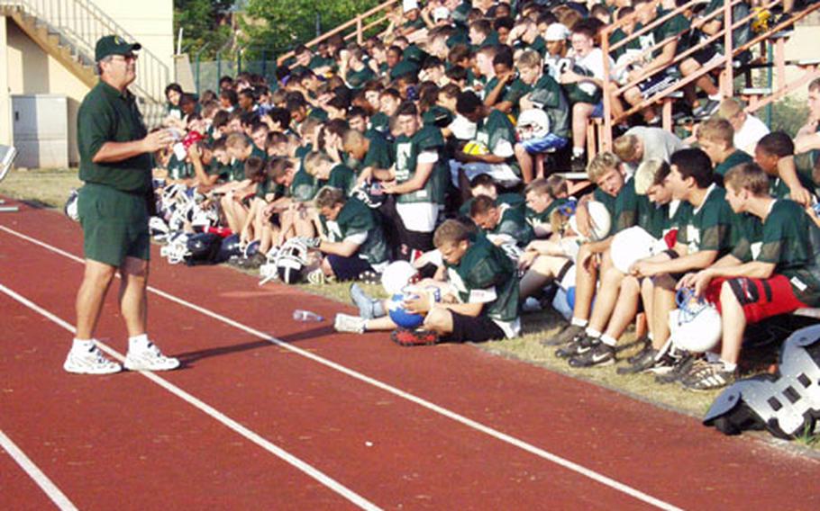 Former Bitburg High School football coach Rik Carr stands on the track that surrounds the field later renamed in his honor to address participants at last summer&#39;s football camp at Bitburg.