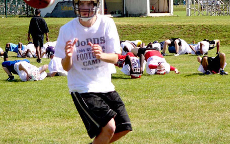 Whiler other players stretch out, Wiesbaden’s Thomas Lawler prepares for his first season of varsity football by taking part in a receiving drill Wednesday.