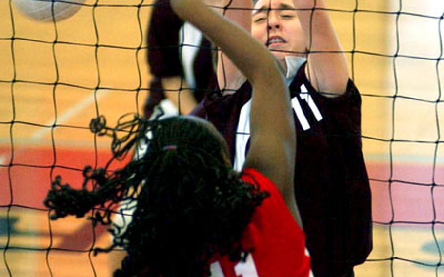 Kaiserslautern’s Dekia Moore, foreground, spikes the ball past AFNORTH’s Rosanna Guzman during a DODDS high school volleyball match in Mannheim, Germany, on Saturday. AFNORTH won the match, 25-10, 25-20, 15-25 and 25-18.