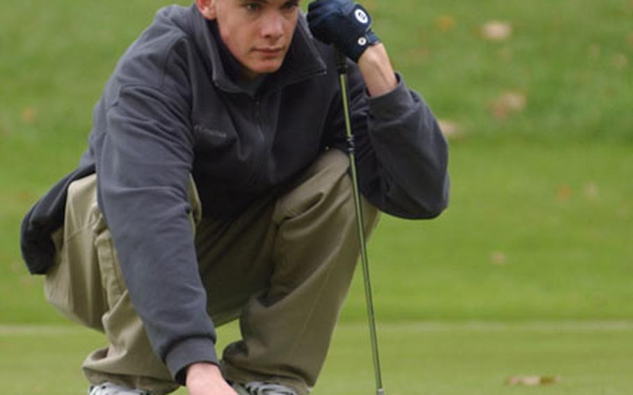 Patch&#39;s Stephen Fey reads the green prior to a putt during the DODDS European Golf Championships on Friday.