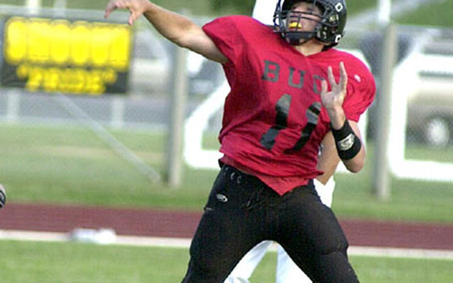 Kadena Buccaneers quarterback Tyler Schmidt unloads a pass on the run against the Kubasaki Samurai during Friday&#39;s game. Schmidt accounted for 185 all-purpose yards, threw a touchdown pass and intercepted two Samurai passes as the Buccaneers won 24-14.