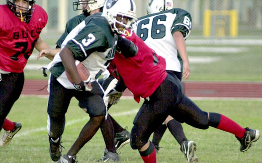 Kubasaki Samurai running back Lenard White (3) eludes a Kadena Buccaneers tackle for a short gain.