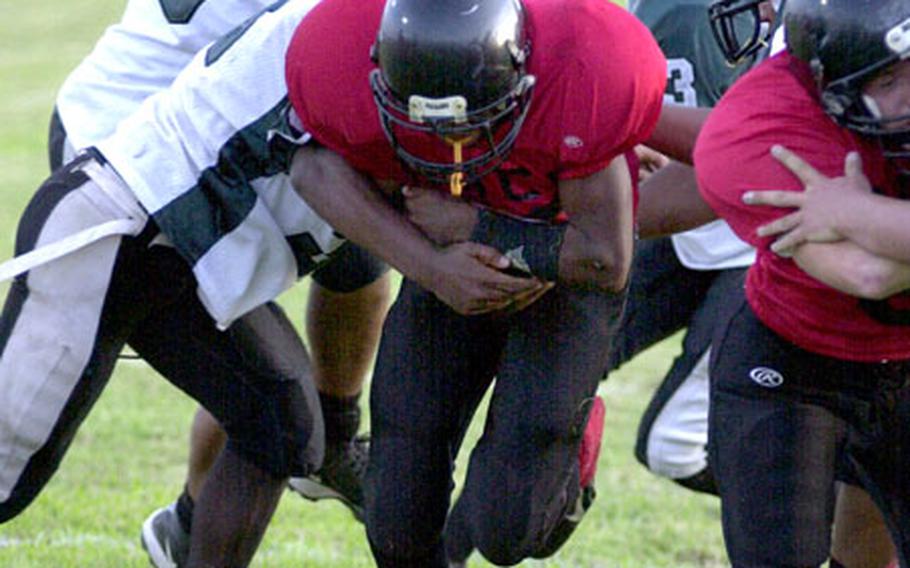 Buccaneers running back Darnell Womach threads his way through Kubasaki Samurai defenders for a one-yard touchdown run on Friday.