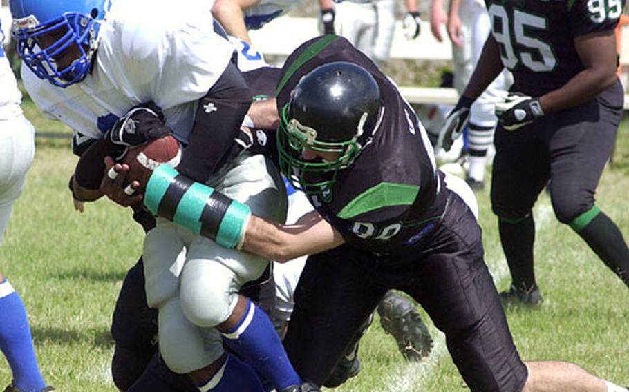 Schwab Panthers running back Jeremy Zenquis gets wrapped up by Kadena Dragons defenders Sam Wicks and Nathan Graves (90) during Saturday&#39;s game at Camp Courtney.