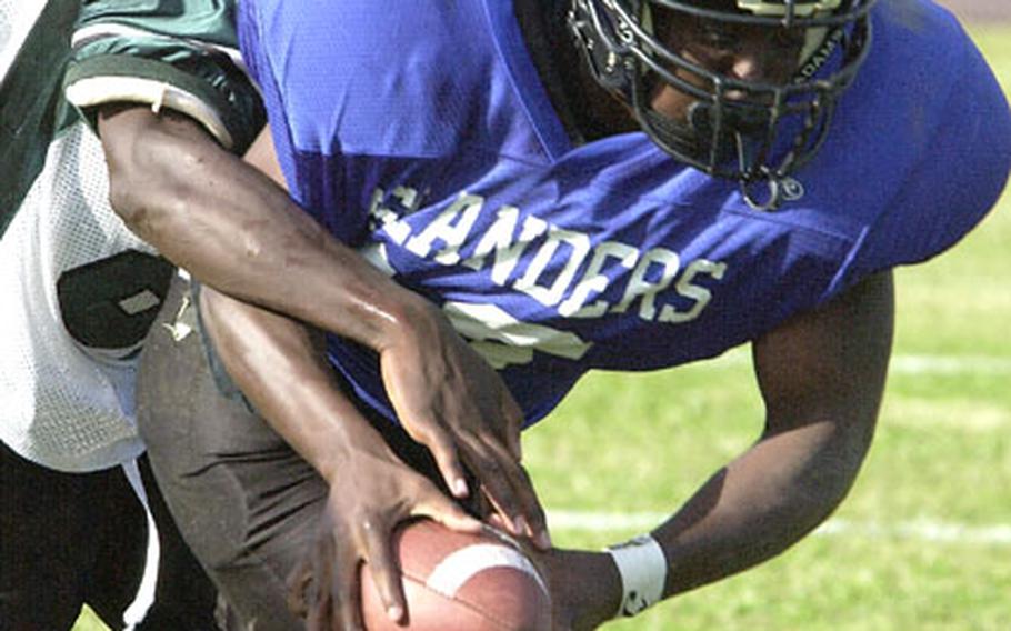 Kadena Islanders running back Keith Loving drags Kubasaki Samurai defender Terry Hilson into the end zone on a 13-yard first-quarter touchdown run Friday. Loving ran 21 times for 223 yards and two touchdowns as the Islanders rallied past the Samurai 17-14 and finished the regular season an unbeaten 6-0.