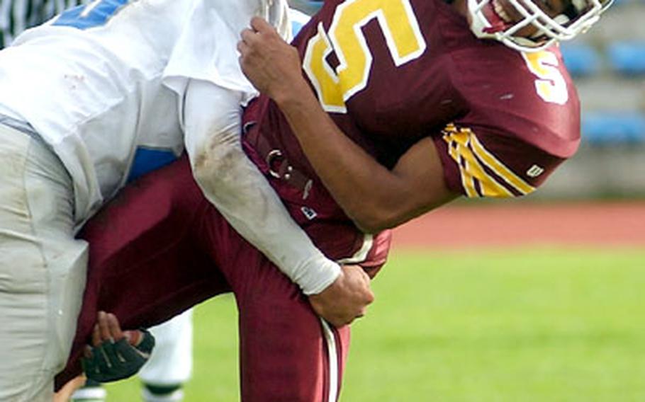 Baumholder&#39;s Rashad Taylor, right, is tackled by Rota&#39;s Joseph Casey during a DODDS Division III football playoff game in Baumholder, Germany, on Saturday. Baumholder defeated Rota 40-29.