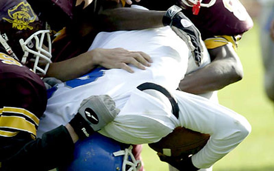 Rota&#39;s Eric McMillan is gang-tackled by Baumholder defenders during Saturday&#39;s game.