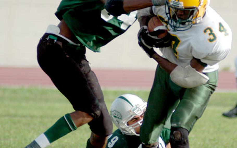 SHAPE running back Steven Small is taken down by Naples defenders senior Mark Pearyer, 84, and Michael Monaco, 39.