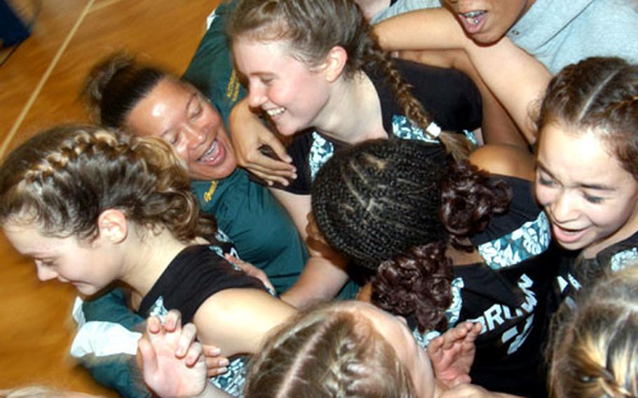 The Alconbury Dragons, along with coach Lisa Westlake, second from left, celebrate their Division IV DODDS volleyball title after defeating Milan 25-20, 20-25, 25-22, 25-16 in Kaiserslautern on Saturday.