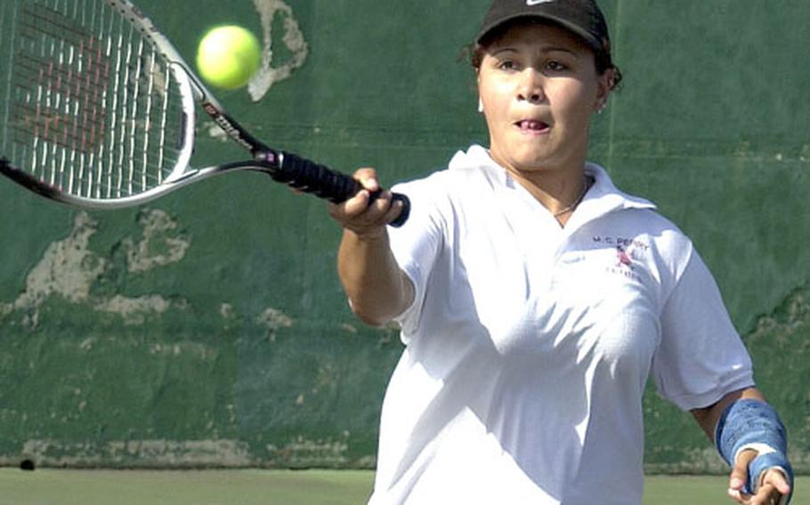 Sporting a cast on her fractured left wrist, Matthew C. Perry Samurai senior captain Rebekkah Claudio hits a forehand return during girls singles play Wednesday in the 2004 Far East High School Tennis Tournament. Claudio lost the second-round match to Kristina DeLeon of Japan&#39;s Yokota Panthers 8-0.