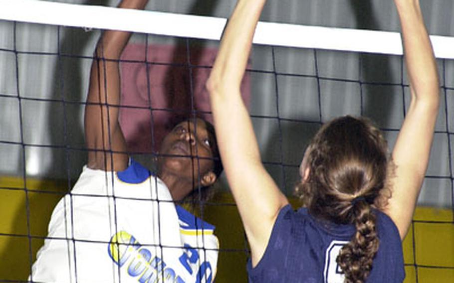 Yokota middle blocker Andrevia Thomas (left) spikes past Seoul American middle blocker Rachel Miller during Friday&#39;s consolation match in the 2004 Far East High School Girls Class AA (large schools) Volleyball Tournament at Kadena High School, Kadena Air Base, Okinawa. Yokota beat Seoul American 20-25, 25-16, 11-25, 25-21, 15-12.