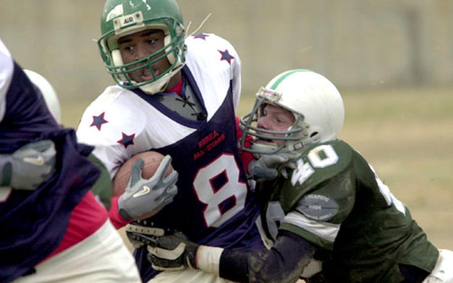 Mychal McGee of Taegu American tries to break free from Singapore American&#39;s Brian Linton during the third quarter of Saturday&#39;s World Bowl.
