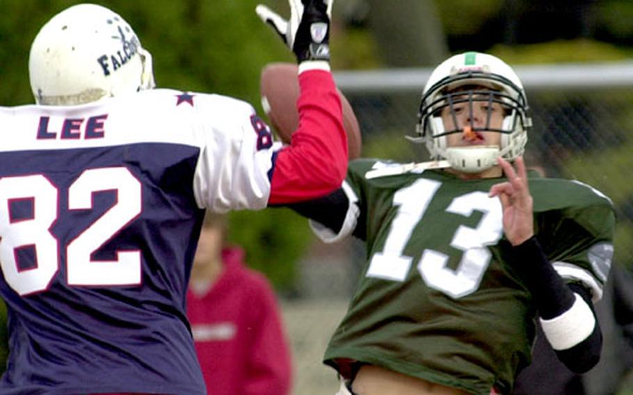 Singapore quarterback Edward Stephens gets off a pass as Justin Lee closes in.