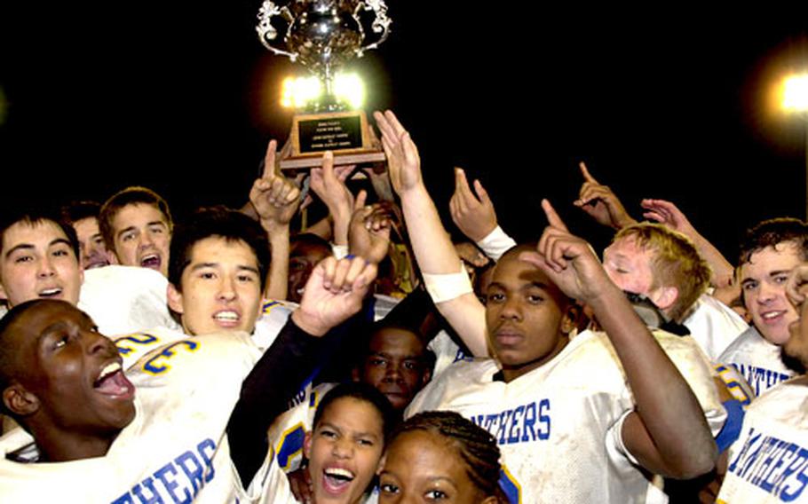 Yokota Panthers players and fans hold aloft the Rising Sun Bowl trophy.