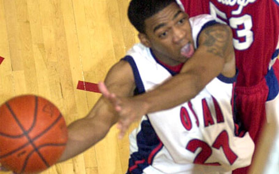 Quinton Smith of the Osan Defenders goes up for a layup against Brett Thomas of the Camp Humphreys Bulldogs during Saturday&#39;s round-robin play. Osan won 73-68.