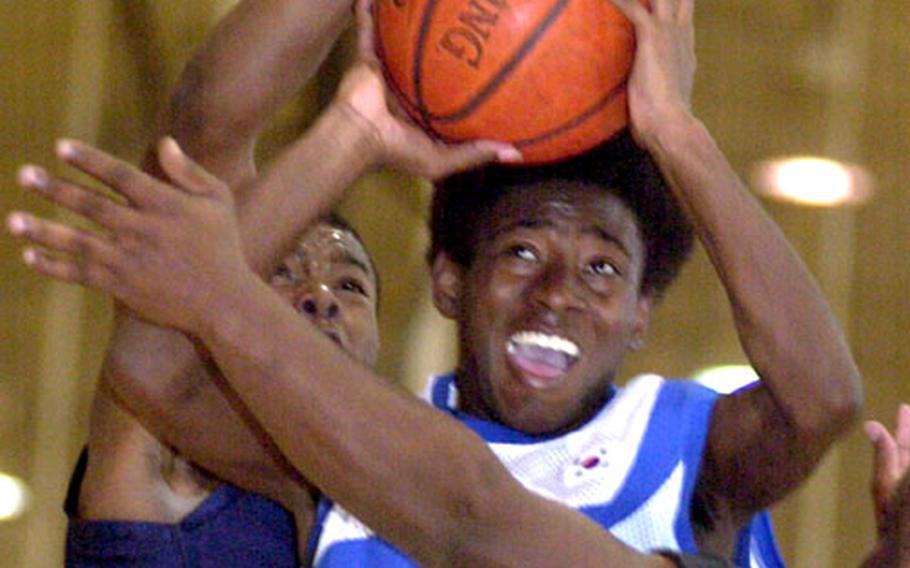 Seoul American Falcons guard Jamaal Mohn (3) tries to put up a shot between Suwon Trail Blazers defenders Desmond Kirby, left, and Maurice Jackson during Sunday&#39;s round-robin play in the 2004 Osan Pacificwide Open Holiday Basketball Tournament. Mohn and the Falcons beat Suwon 68-42.