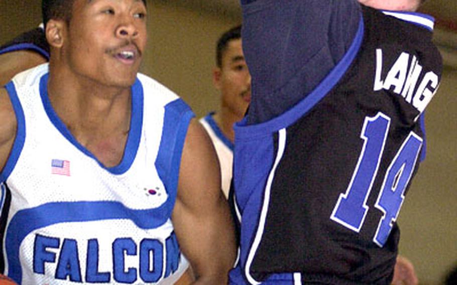 Seoul American forward Justin Lee (32) finds his path to the basket blocked by Suwon defender Joseph Lavigne on Sunday at Osan Air Base, South Korea. The Falcons won 68-42.